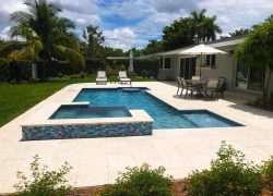 A backyard with a pool constructed and accompanied by patio furniture.